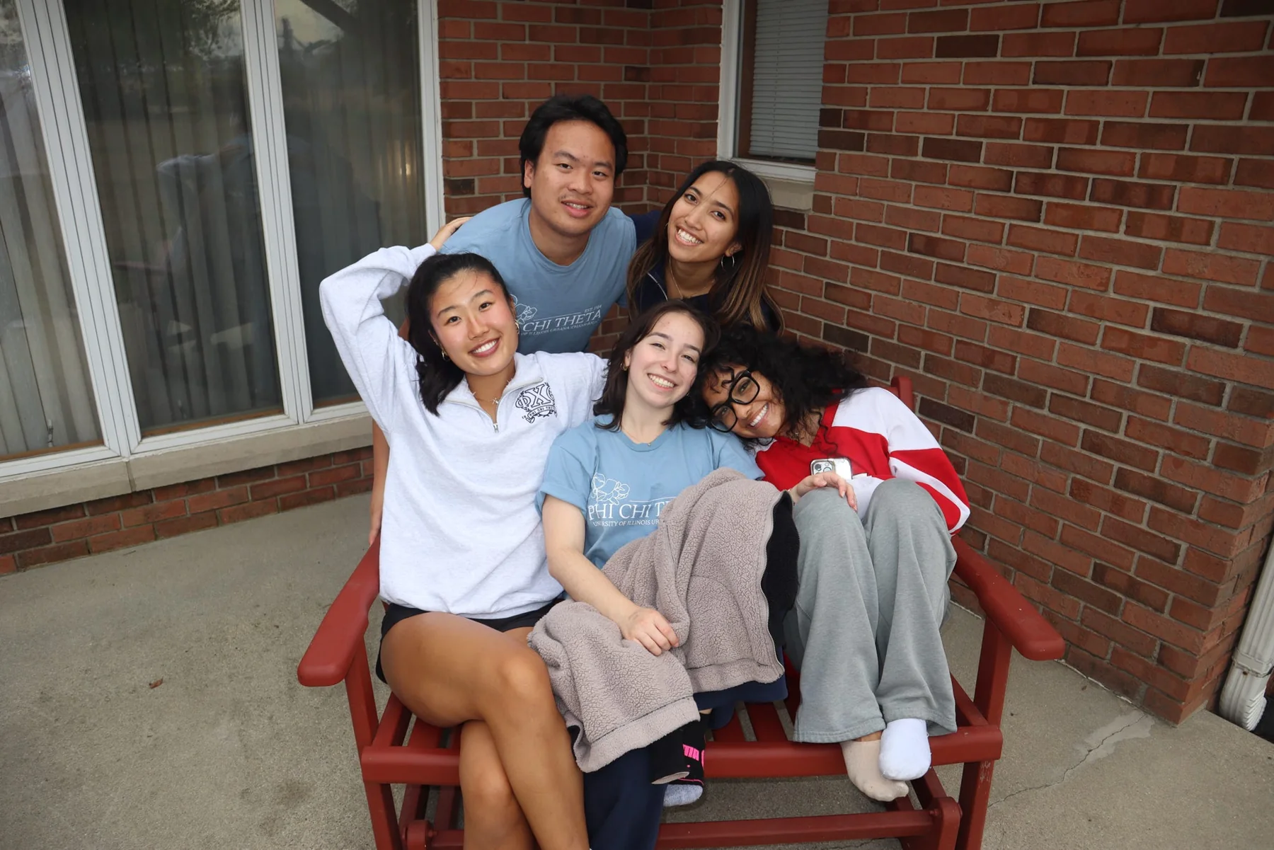 PCT friends sharing a chair on a porch